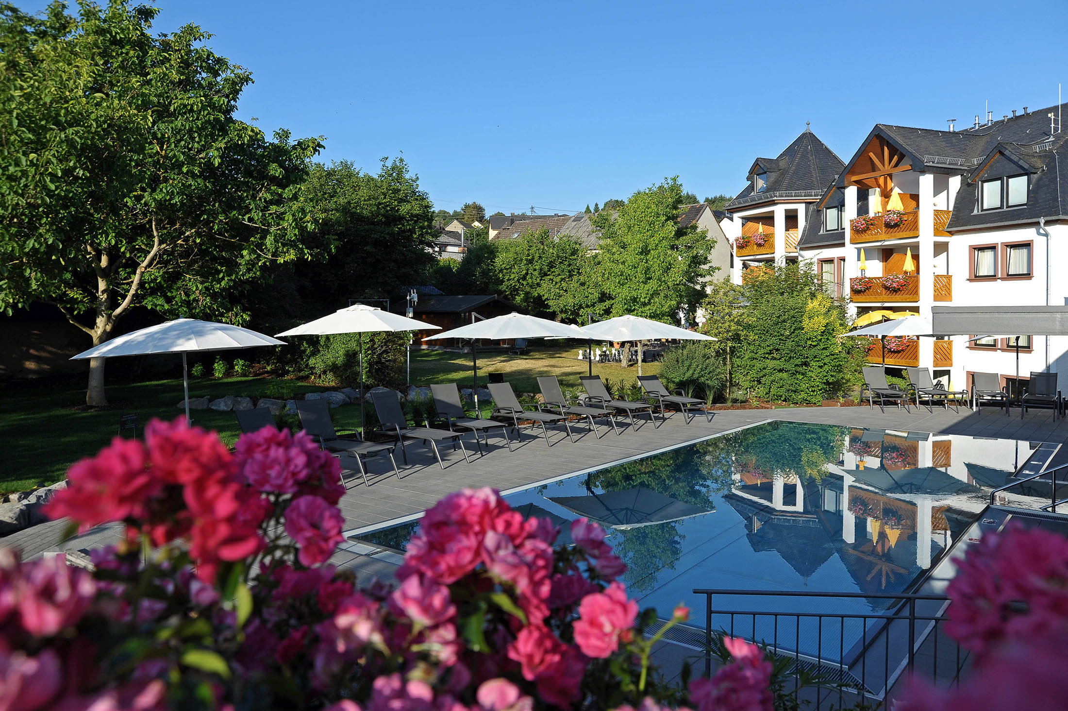 Außenpool mit Blick aufs Michels Wohlfühlhotel in der Eifel